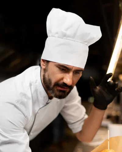 Carlo: chef con giacca bianca e cappello da cuoco